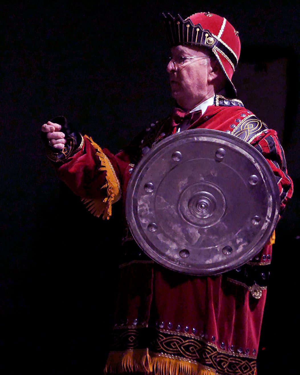 Brother in ceremonial degree regalia holding a shield during degree work
