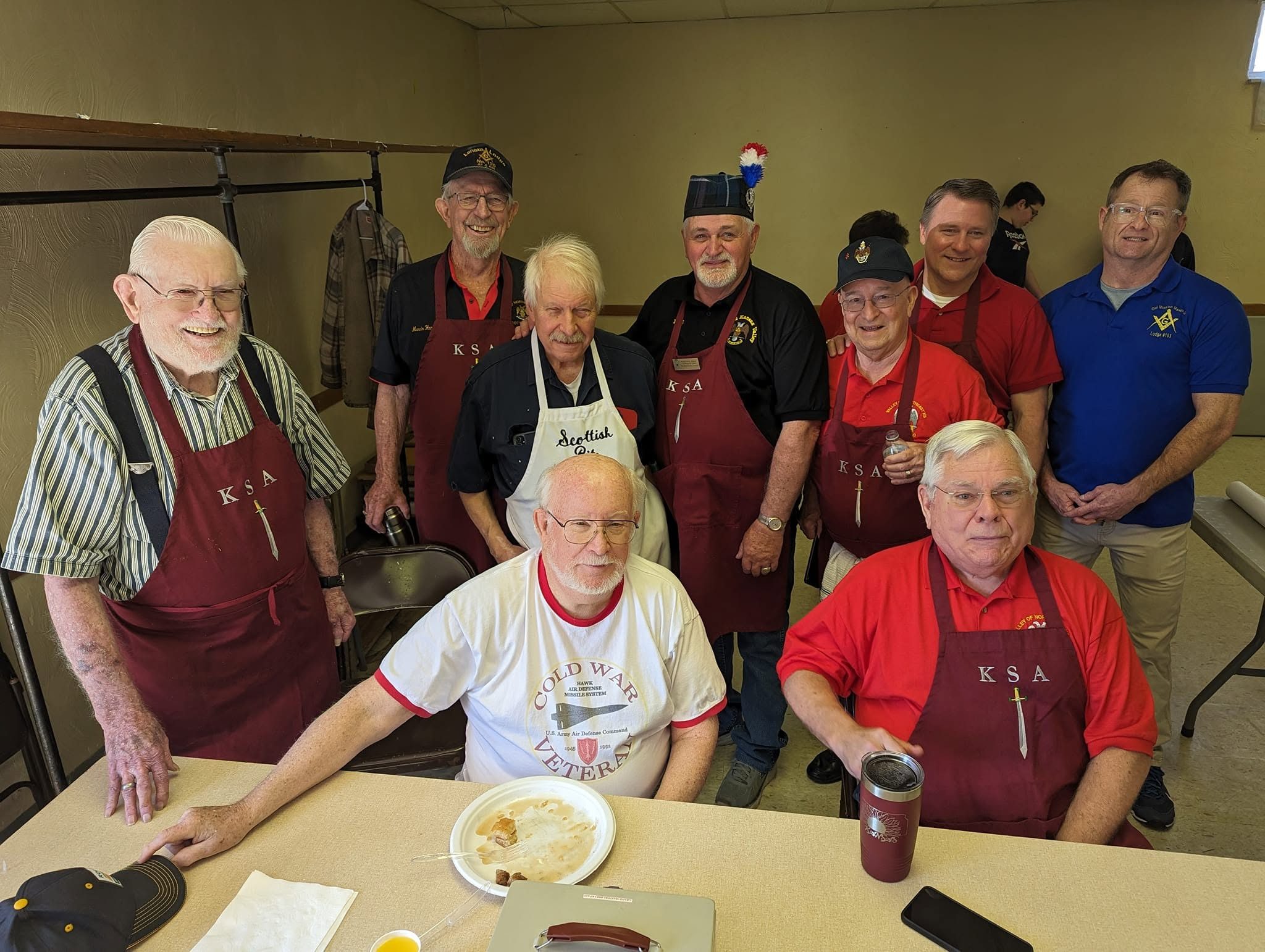Knights of St. Andrew in red aprons serving at a Valley meal
