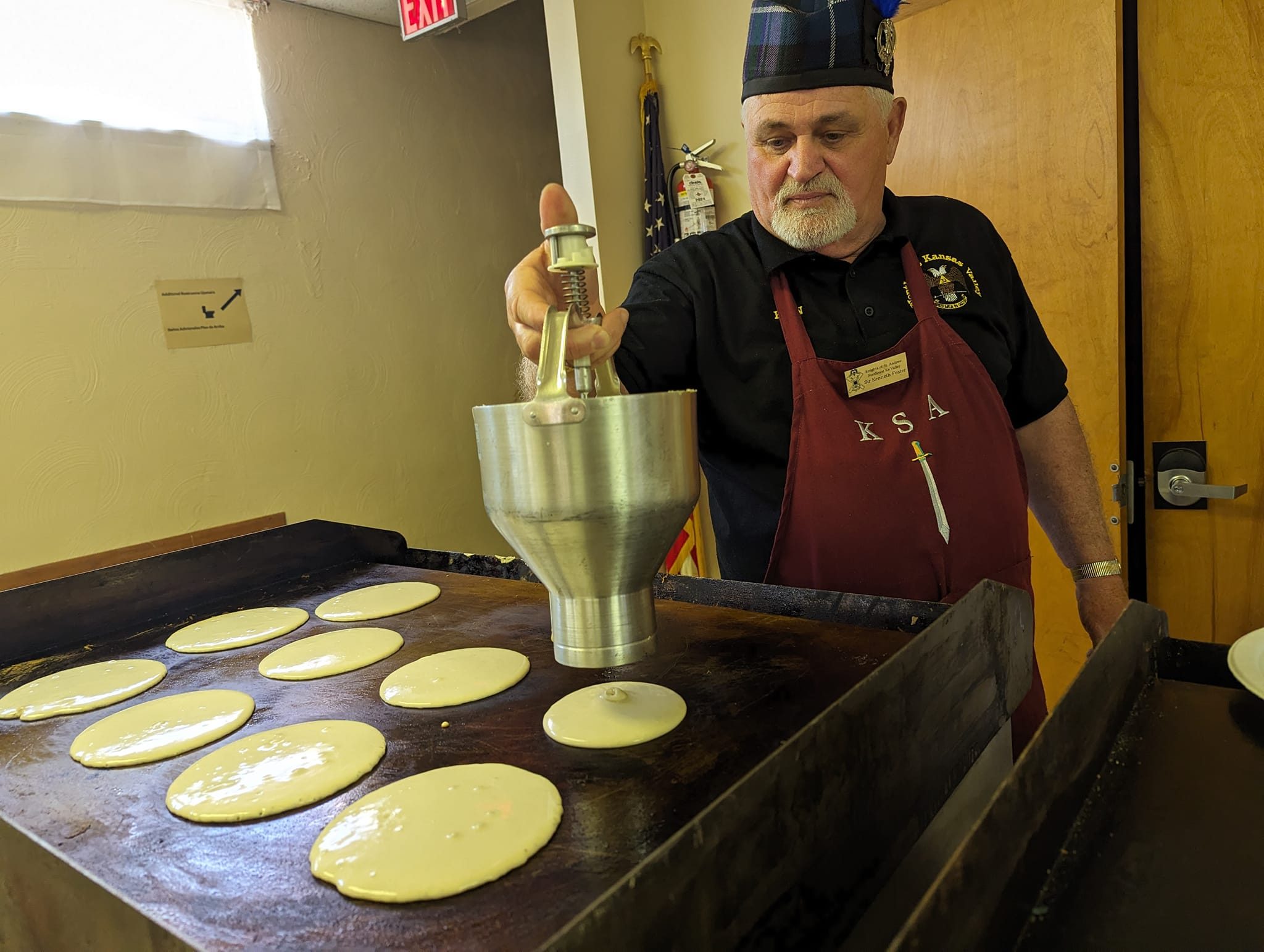 Brother pouring batter on the griddle at the Valley annual pancake breakfast